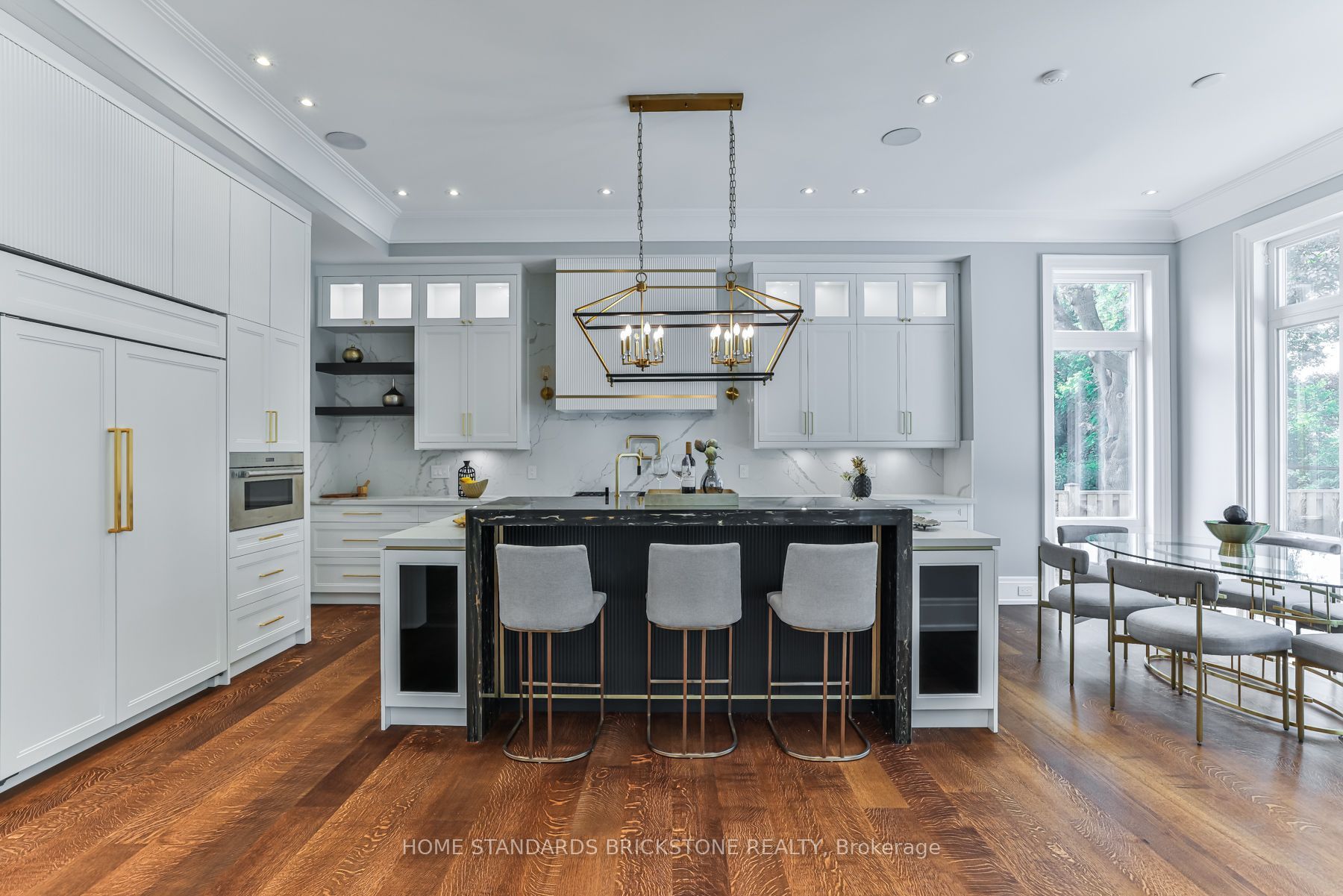 White kitchen with fluted black marble island and brass accents