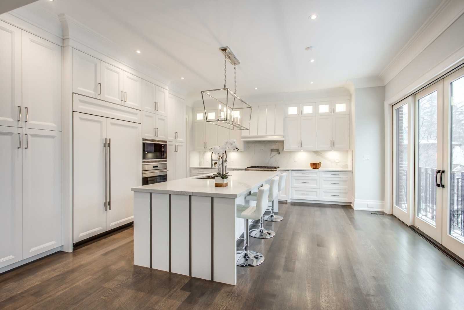 Bright white kitchen with panelled appliances and island seating