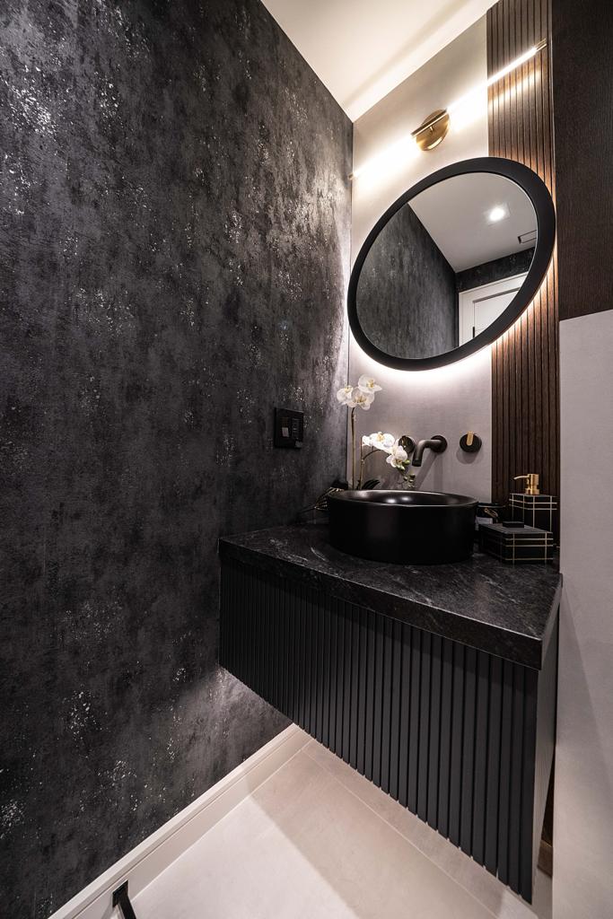 Powder room with fluted black floating vanity, vessel sink and backlit round mirror — Bedford project