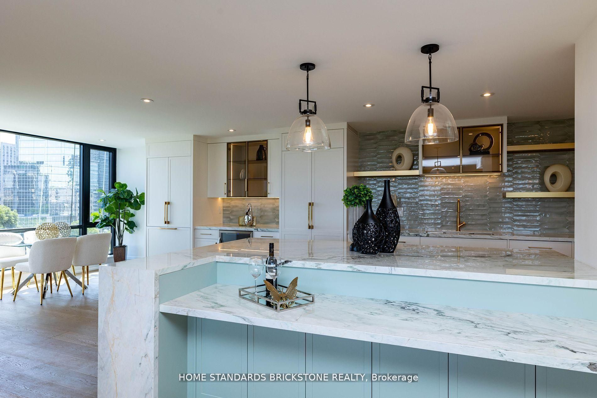 Marble waterfall island with aqua base and bronze-framed glass display cabinets