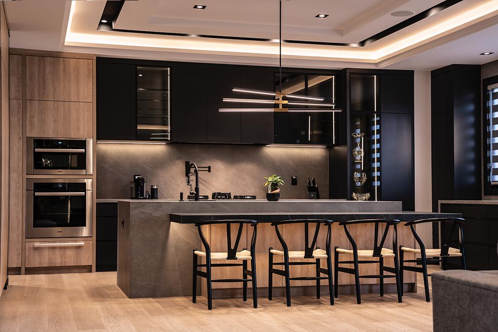 Dark modern kitchen with black cabinetry, walnut accents and stone island — Wynne project