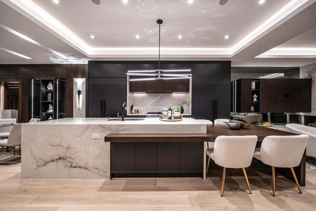 Dark modern kitchen with marble waterfall island and walnut dining ledge — Bedford project
